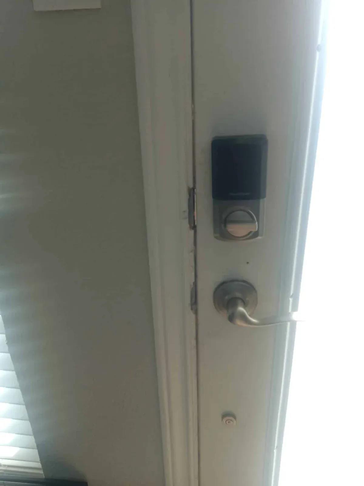 Close view of a deadbolt and handle on a white entry door.