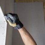 Close-up of drywall being repaired with plaster