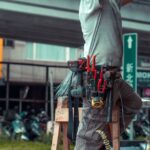 Handyman on ladder with tool belt working on home repair